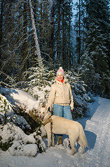 Image showing Woman with dog in winter forest on a walk