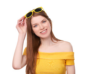 Image showing Smiling redheaded female in yellow top and sunglasses