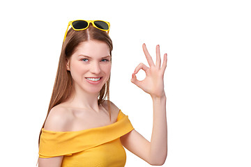 Image showing Redheaded female in yellow gesturing OK