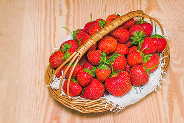Image showing Basket of strawberries on the table surface.