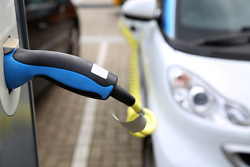 Image showing Electric car being charged at the station, close up of the power