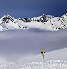 Image showing Warning sing on off-piste slope and mountains in fog