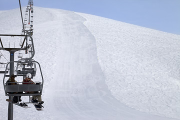 Image showing Snowboarders on chair-lift and ski slope