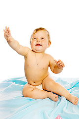 Image showing baby in diaper sitting on a blue blanket. Isolated