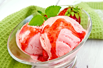 Image showing Ice cream strawberry with syrup in glass on board