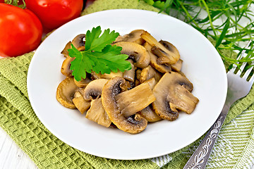Image showing Champignons fried in plate with parsley on light board