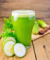 Image showing Juice cucumber in tall glass on board with knife