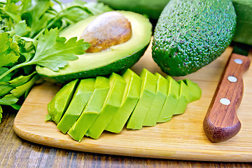 Image showing Avocado slices on board with knife