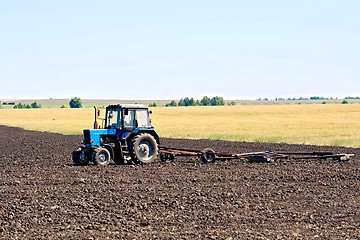 Image showing Tractor wheeled plowing