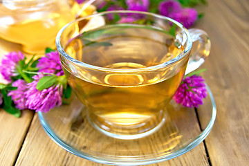 Image showing Tea with clover in cup and teapot on board