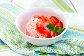Image showing Ice cream strawberry with syrup in bowl on napkin