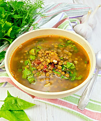 Image showing Soup lentil with spinach in bowl on light board