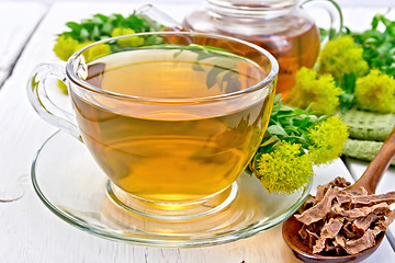 Image showing Tea of Rhodiola rosea in cup with spoon on board