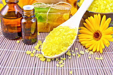 Image showing Salt yellow and oil with calendula on bamboo