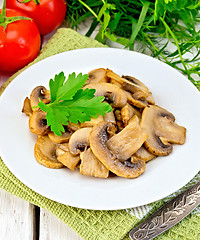 Image showing Champignons fried in plate on napkin and board