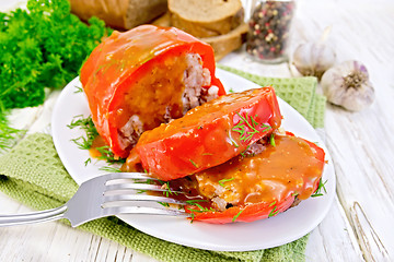 Image showing Pepper stuffed meat with sauce and fork in plate on table