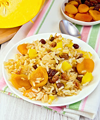 Image showing Pilaf fruit with pumpkin in white plate on light board