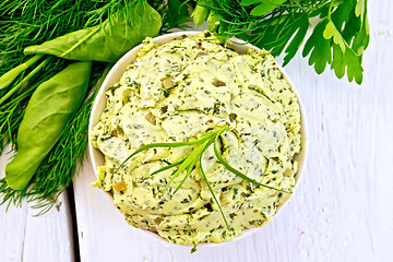 Image showing Butter with spinach and herbs in bowl on light board