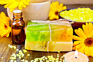 Image showing Soap homemade and oil with calendula on board