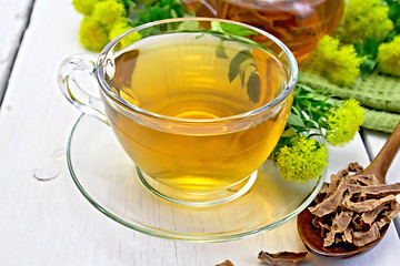 Image showing Tea of Rhodiola rosea in cup with spoon on light board