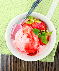 Image showing Ice cream strawberry with syrup in bowl on board