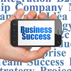 Image showing Finance concept: Hand Holding Smartphone with Business Success on display