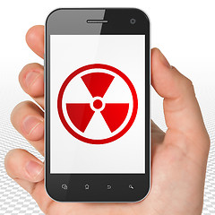 Image showing Science concept: Hand Holding Smartphone with Radiation on display