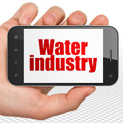 Image showing Manufacuring concept: Hand Holding Smartphone with Water Industry on display