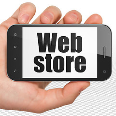 Image showing Web design concept: Hand Holding Smartphone with Web Store on display