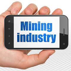 Image showing Industry concept: Hand Holding Smartphone with Mining Industry on display