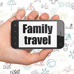 Image showing Travel concept: Hand Holding Smartphone with Family Travel on display