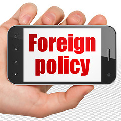 Image showing Politics concept: Hand Holding Smartphone with Foreign Policy on display