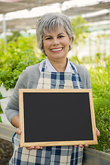 Image showing Elderly woman in a green house