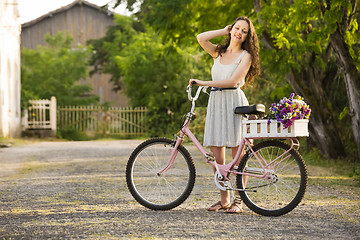 Image showing Happy girl with her bicycle