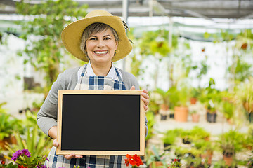 Image showing Elderly woman in a green house