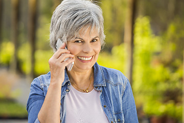 Image showing Mature woman talking at phone