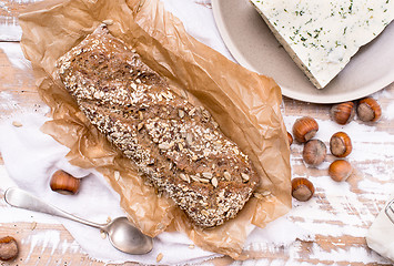 Image showing Bread with seeds cheese and huzelnuts on wooden board