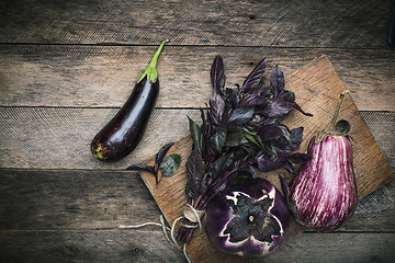 Image showing Aubergines and basil on chopping board 