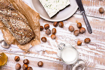 Image showing Tasty Bread with seeds huzelnuts and cheese on board