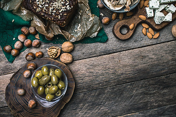 Image showing nuts mushrooms bread and olives on wooden table