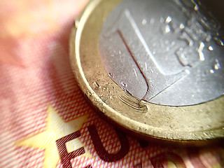 Image showing A scratched 1€ coin over a 10€ banknote