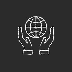 Image showing Two hands holding globe icon drawn in chalk.