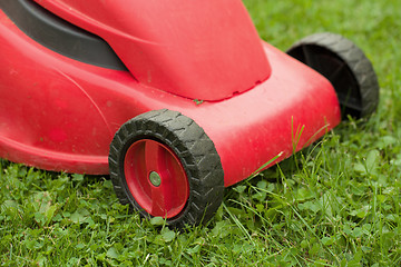 Image showing red lawnmower on green grass