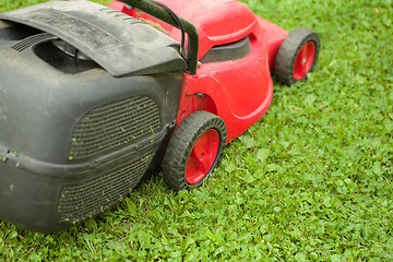 Image showing red lawnmower on green grass