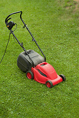 Image showing red lawnmower on green grass