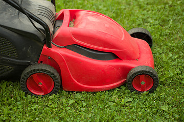 Image showing red lawnmower on green grass