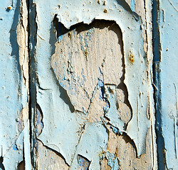 Image showing stripped paint in the blue wood door and rusty nail