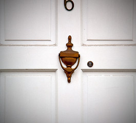 Image showing handle in london antique brown door  rusty  brass nail and light