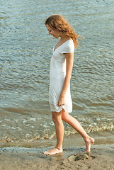 Image showing Pretty woman in a white dress on coast