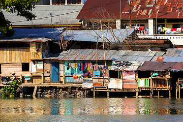 Image showing Straw poor houses by the river